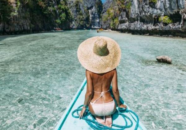 back-view-of-the-young-woman-in-straw-hat-relaxing-on-the-boat-and-looking-forward-into-lagoon-travelling-tour-in-asia-el-nido-palawan-philippines