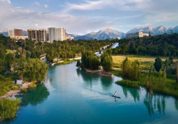 top-down-aerial-drone-shot-of-man-at-stand-up-paddle-boards-sup-in-the-river-and-mountain-lake-sairan-in-city-almaty-in-kazakhstan