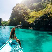 back-view-of-the-young-girl-relaxing-on-the-boat-and-looking-at-the-island-travelling-tour-in-asia-el-nido-palawan-philippines