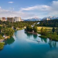 top-down-aerial-drone-shot-of-man-at-stand-up-paddle-boards-sup-in-the-river-and-mountain-lake-sairan-in-city-almaty-in-kazakhstan